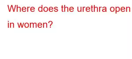 Where does the urethra open in women?